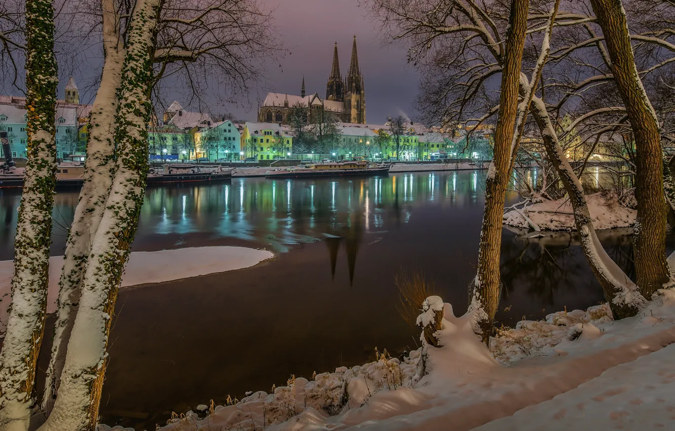 Фото обои зима, снег, деревья, город, река, здания, дома, вечер, Германия, Бавария, освещение, башни, Регенсбург, Дунай